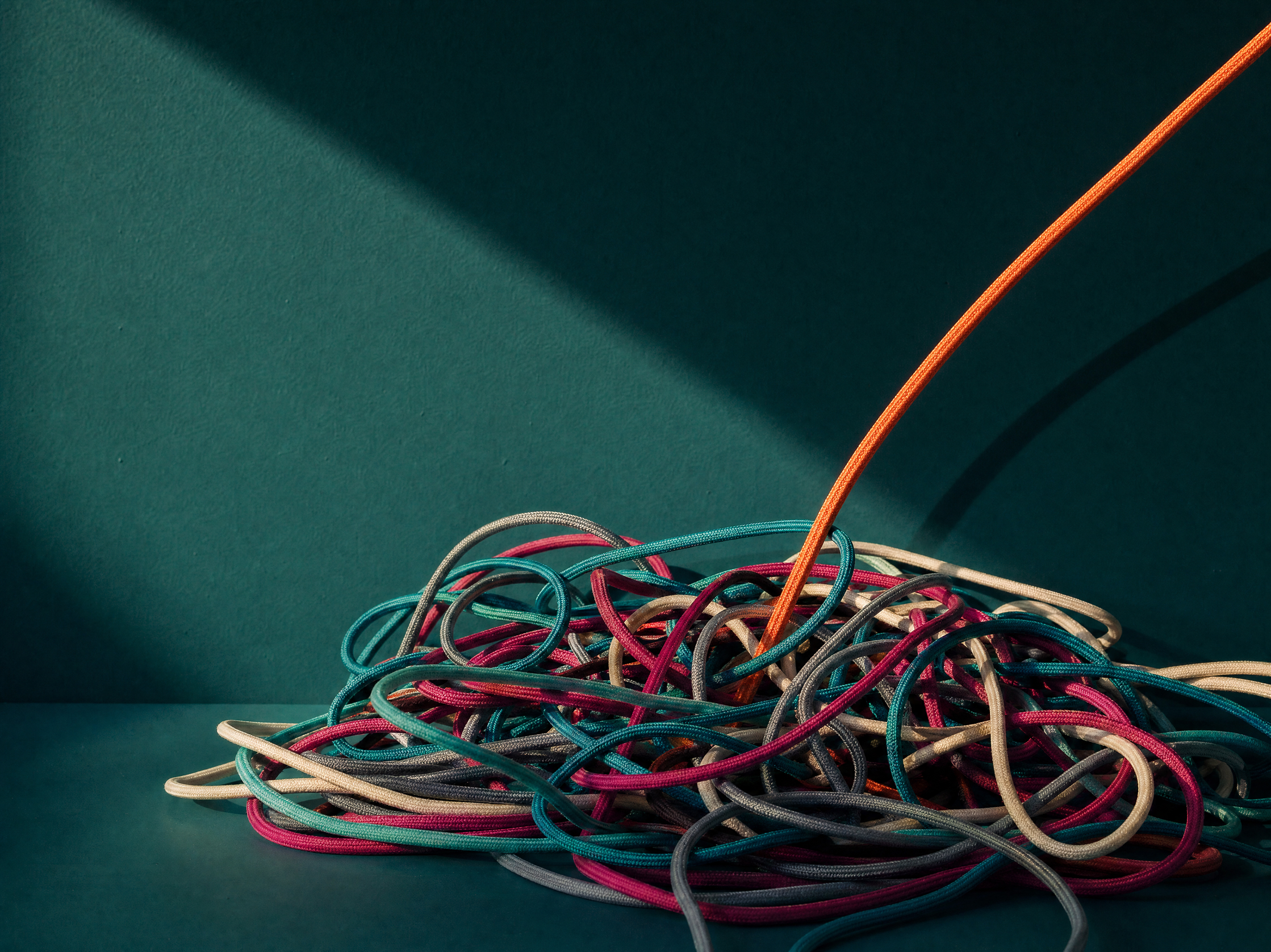 Orange Cord Extracted From Tangled Heap Of Wires