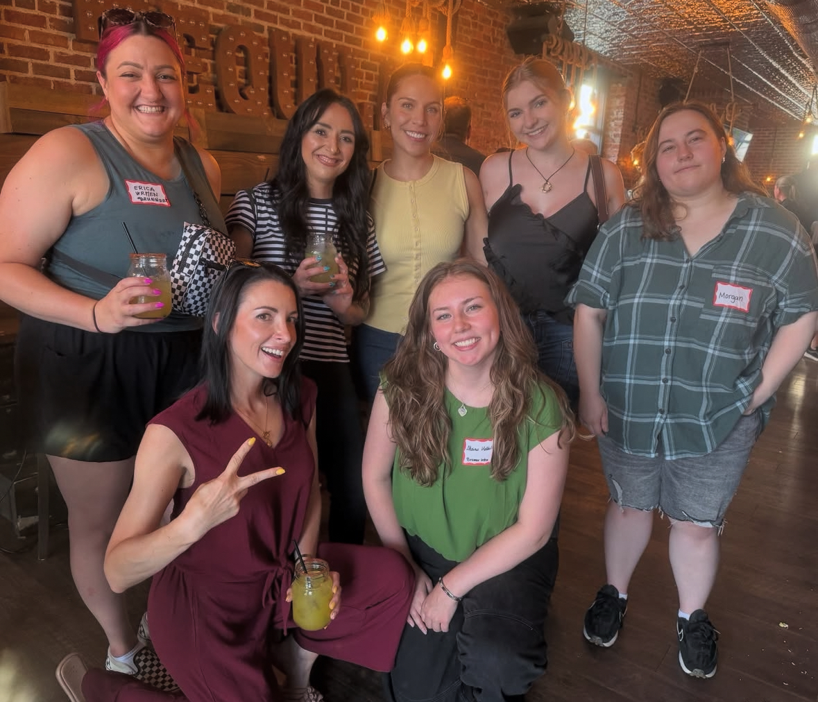 Team members smiling together at a brewery with drinks