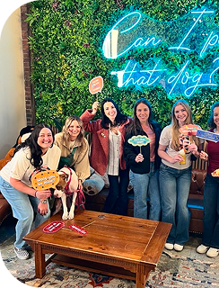 Brunner employees standing in front of a neon sign that say, can I pet that dog