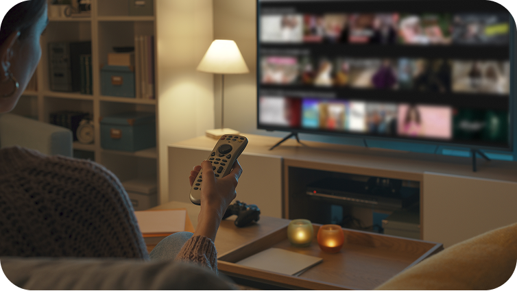 A person holding a remote pointing at a tv with a dashboard displaying