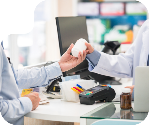 close up of a medicine bottle being handed from one person to another in a pharmacy setting
