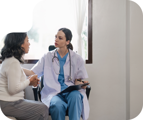 a person in a white lab coat with a stethoscope and tablet talking to a patient