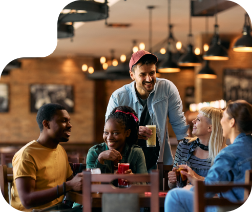 Group of friends laughing around a table at a restaurant