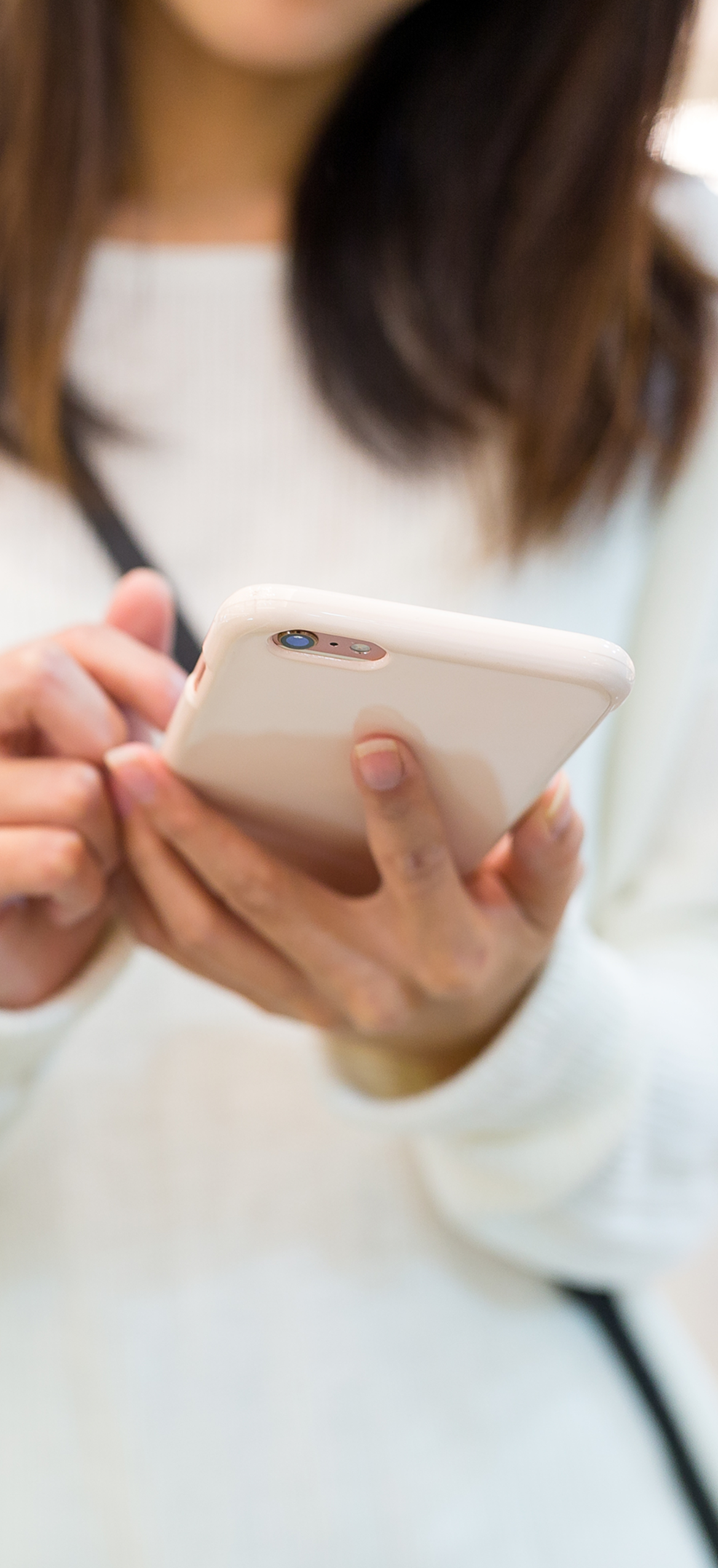 Person checking their phone while holding it in both hands