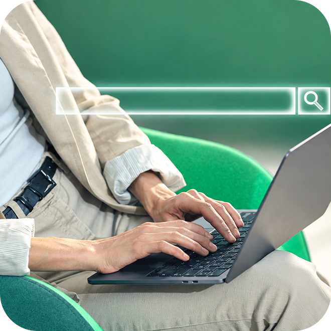A person typing on a laptop with a search bar overlaying the image.