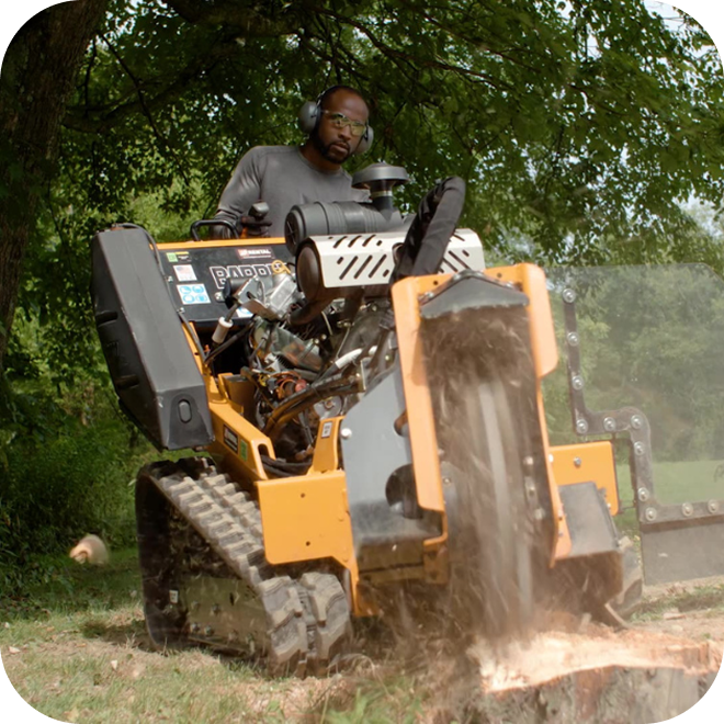 A person running a stump grinder