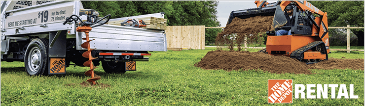 A skidsteer digging dirt in a yard with a home depot rental truck with an auger leaning against it.