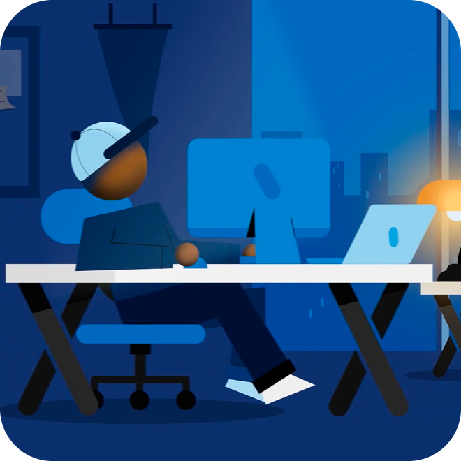 An illustration of a person sitting at a desk with a monitor and a laptop.