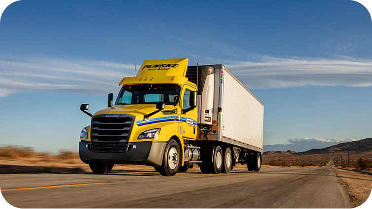 A Penske truck driving down a road